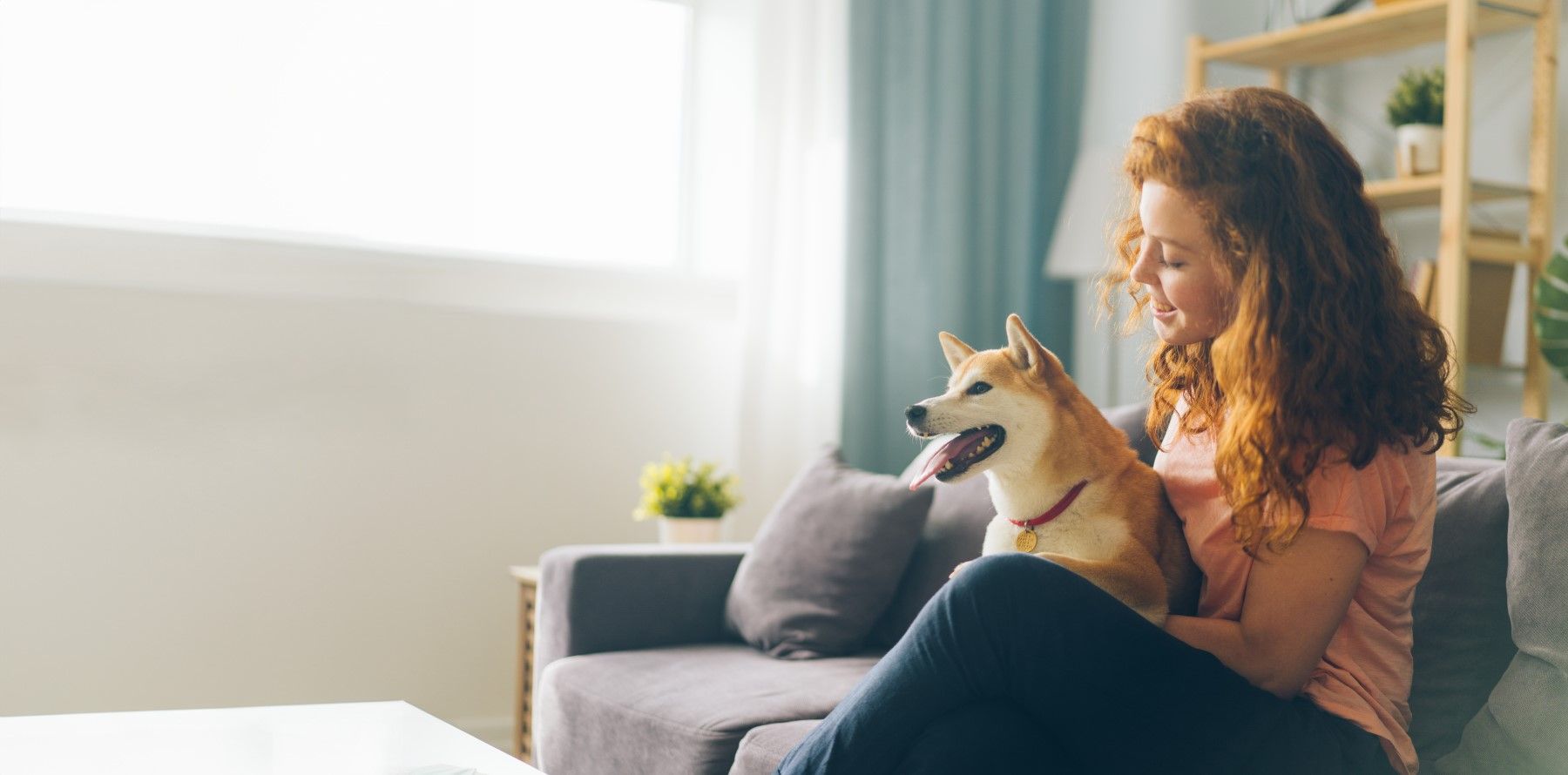 a girl sitting on the couch with a dog